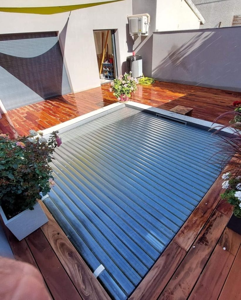 Terrasse bois moderne avec couverture de piscine automatique à lames