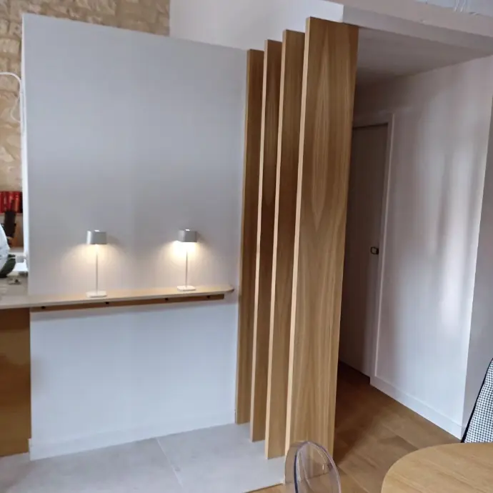 Fixation murale discrète d'un claustra en bois dans un intérieur moderne à Plan-de-Cuques